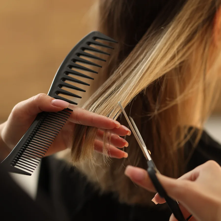 Detalhe de corte de cabelo com pente e tesoura